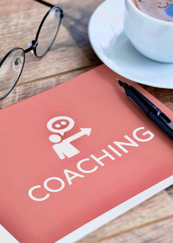 Auf einem Tisch steht eine Tasse Kaffe, eine Brille und ein Consulting Buch